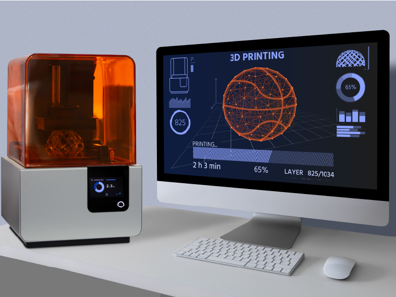 A computer screen with a 3D model of a basketball. Next to the computer is a 3D printer. Engineering the 3D-Printed, Airless Basketball